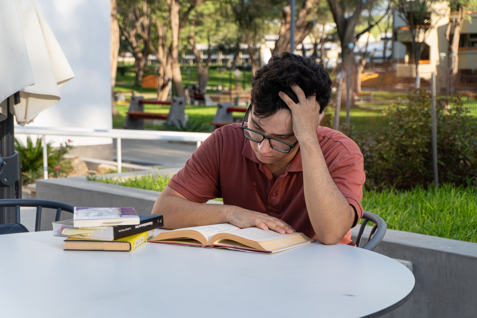 Üniversite kampüsünde kitap çalışan erkek öğrenci