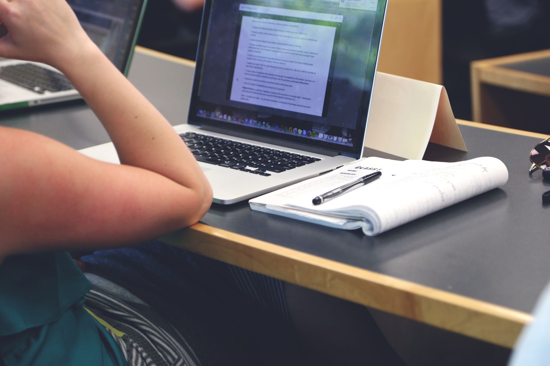Laptop önünde not tutan öğrenci